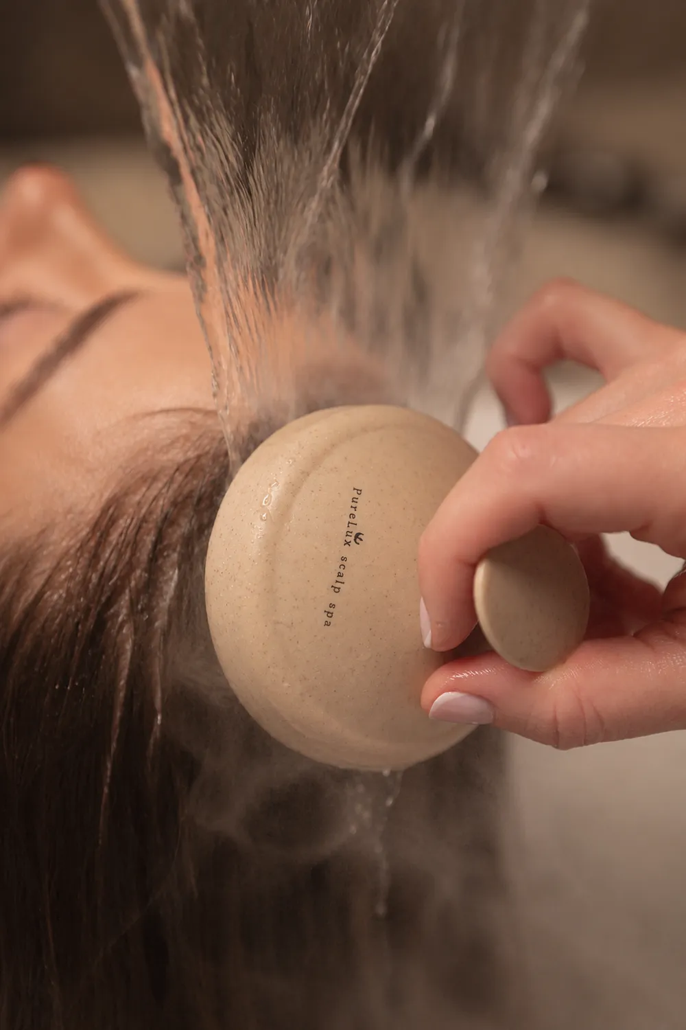 Warm water rinsing a guest's hair during a Purelux ritual